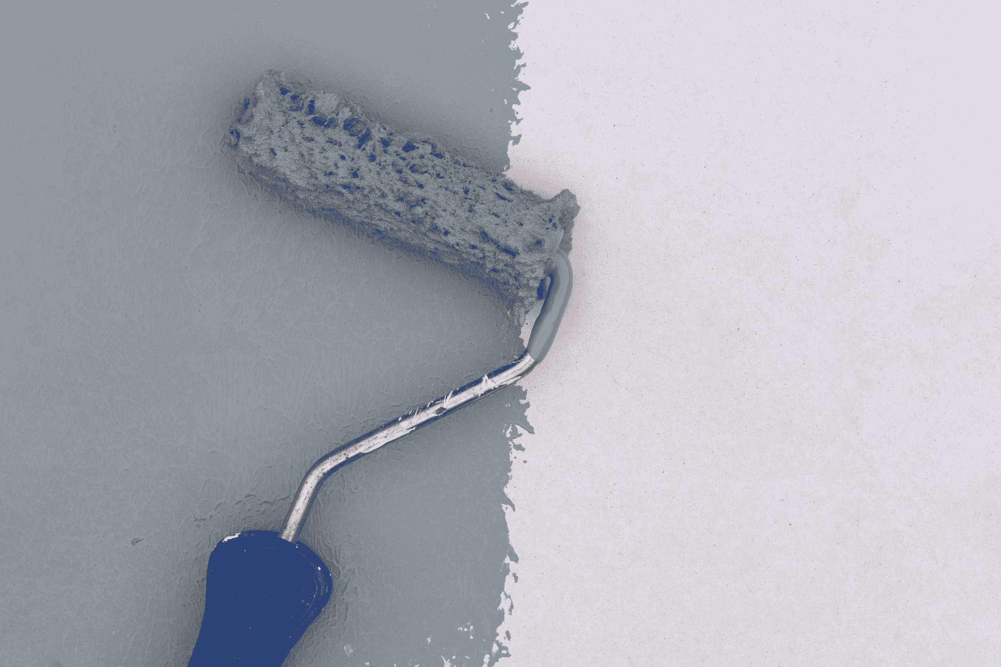 A paint roller on a wall spreads white paint, highlighting the repainting of commercial buildings in Sydney.
