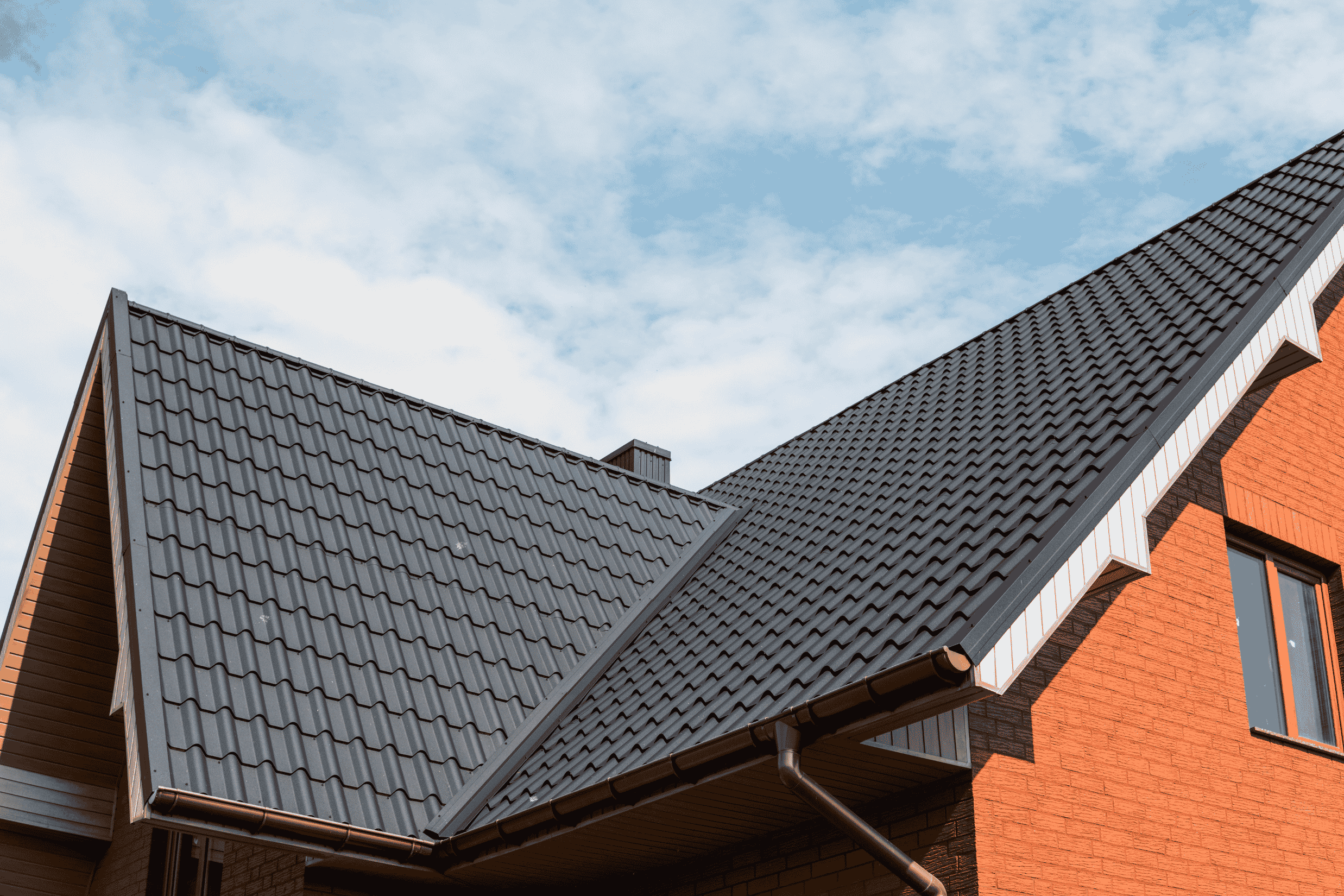 A house featuring a metal roof and a white roof, showcasing roof painting and restoration services in Sydney.