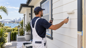 Best Temperature to Paint Outside: Expert Advice Guide : Professional painter checking weather conditions while painting a Sydney home exterior
