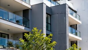 Modern Australian apartment building with painted exterior walls, glass balconies and landscaped surroundings